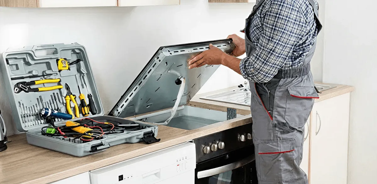Handyman repairing a cooktop and checking wiring connections in Des Moines, IA