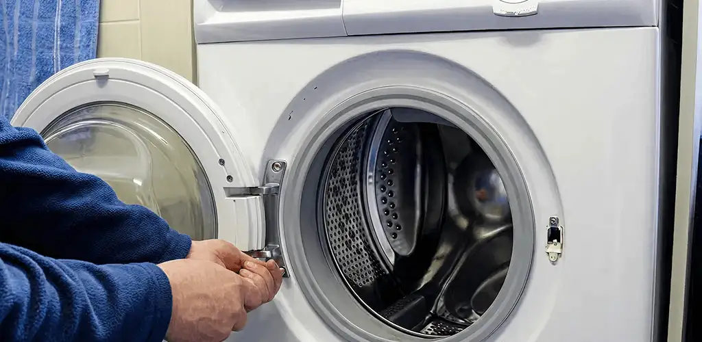 Washing machine repair handyman checking a front-load washer door and latch in Des Moines, IA