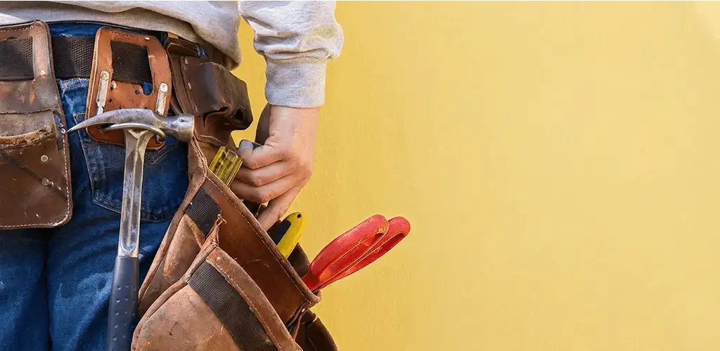 Handyman with tool belt ready for home repairs and maintenance in Des Moines, IA