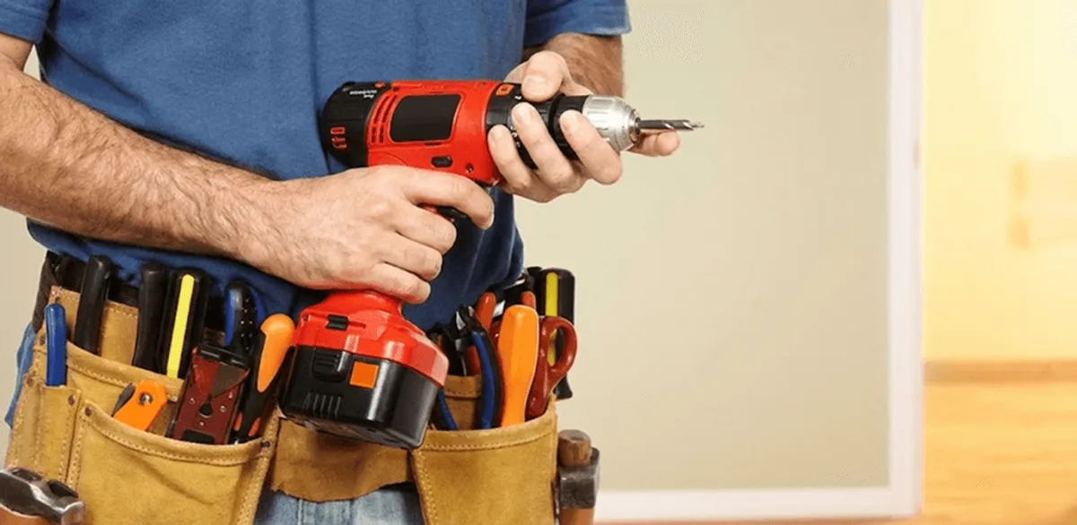 Handyman holding a power drill for home repairs and installations in Des Moines, IA