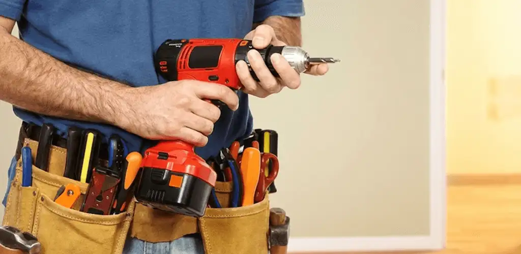 Handyman holding a power drill for home repairs and installations in Des Moines, IA