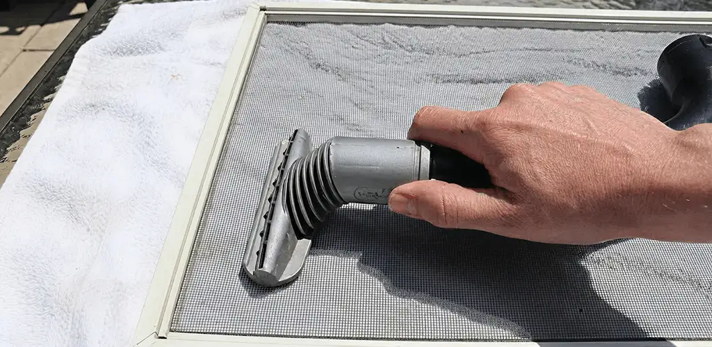 Window screen repair cleaning and fixing a damaged screen mesh in Des Moines, IA